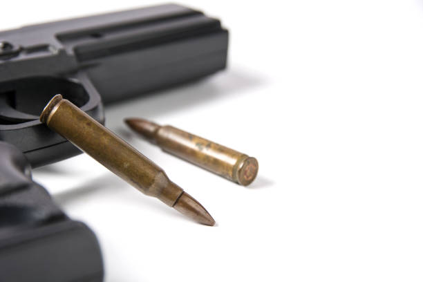 istock Hand gun sitting with m-16 bullets isolated on white background. 803212398