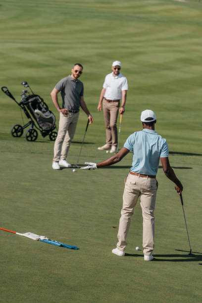 istock young multiethnic golfers talking during the game on green pitch at daytime 803212416