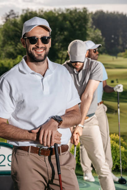 istock portrait of smiling golfer looking at camera while men playing golf 803212720