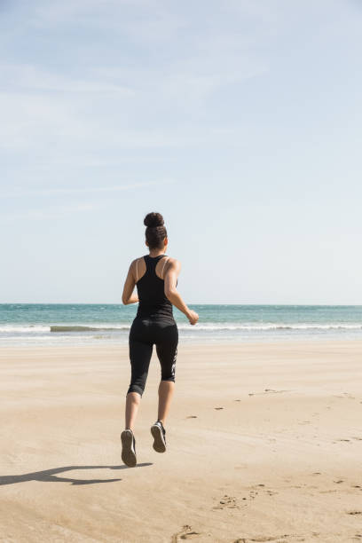 istock Fit woman jogging on the sand 803212850
