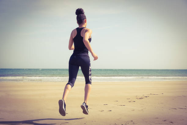 istock Fit woman jogging on the sand 803212892