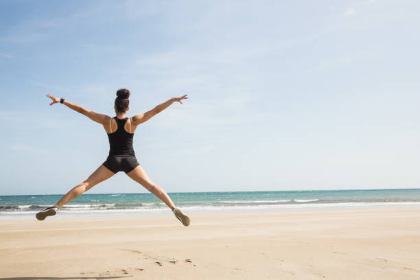 istock Fit woman leaping on the sand 803213038