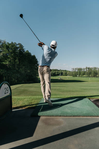 istock back view of stylish man playing golf alone at golf course 803220186