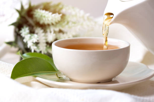 istock Close up pouring hot black tea in a white tea cup ,  Tea ceremony time concept 803220420