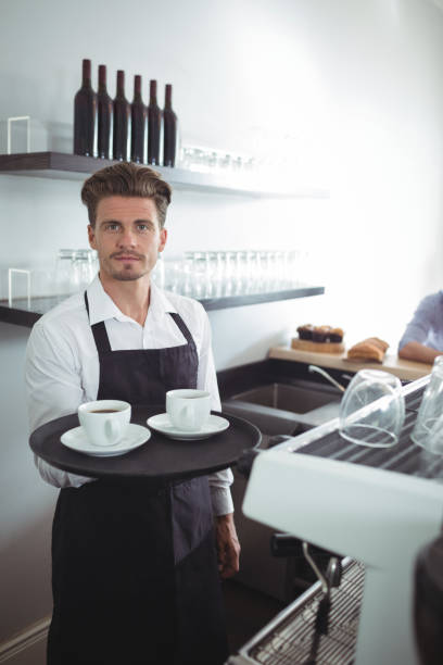istock Waiter holding coffee in tray at counter 803225468