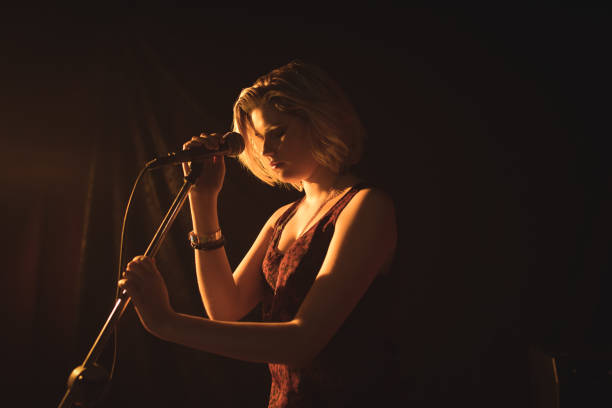 istock Female singer holding microphone in nightclub 803233208
