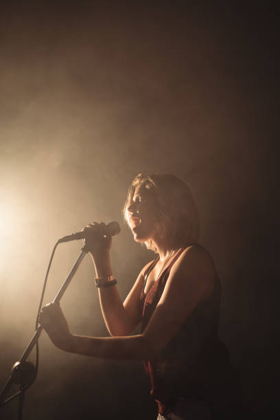 istock Female singer performing in illuminated nightclub 803235326