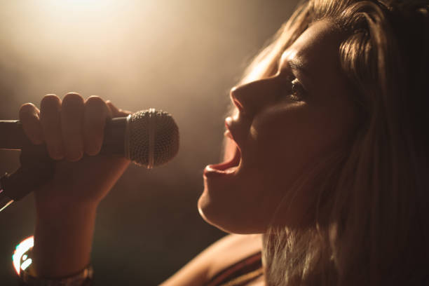 istock Confident female singer performing in illuminated nightclub 803235366