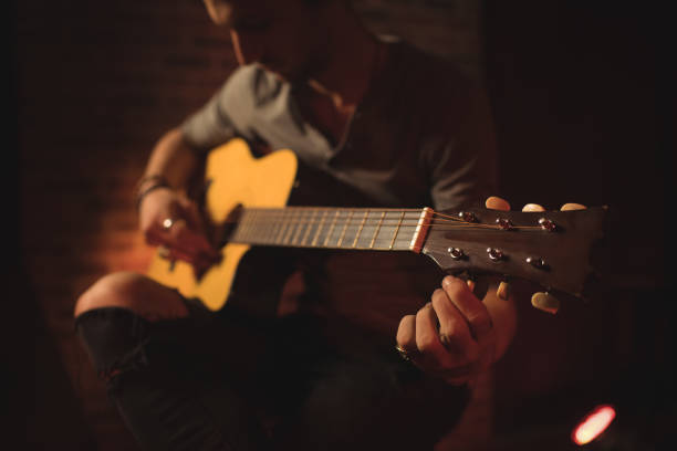 istock Mid section of male guitarist performing 803235422