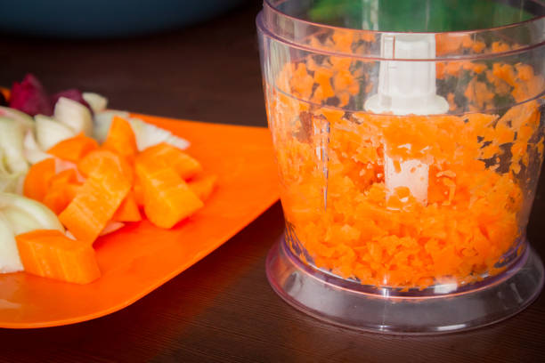 istock Carrots for borsch in an electric chopper. Soup cooking. 803241356