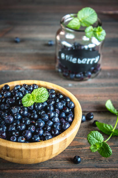 istock blueberries in a bowl on a wooden table. 803241488
