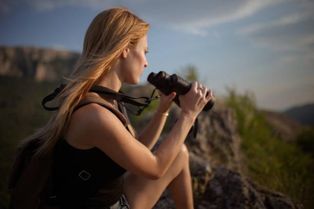 istock Beautiful girl looking through binoculars 803250398