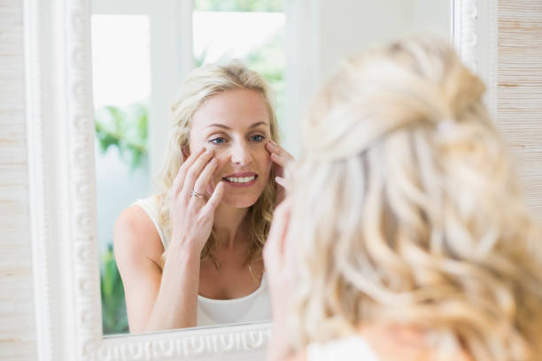 istock Beautiful woman looking at herself in the mirror 803253546