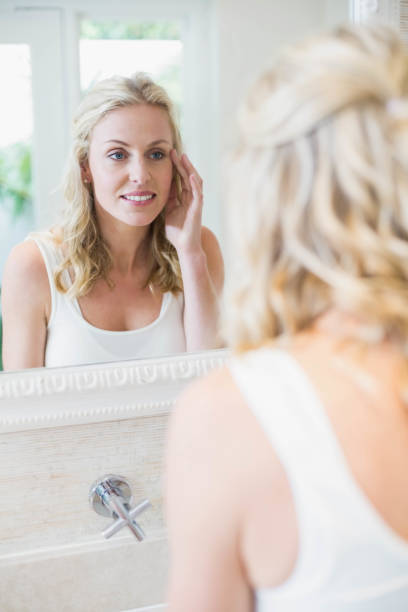 istock Beautiful woman looking at herself in the mirror 803254864