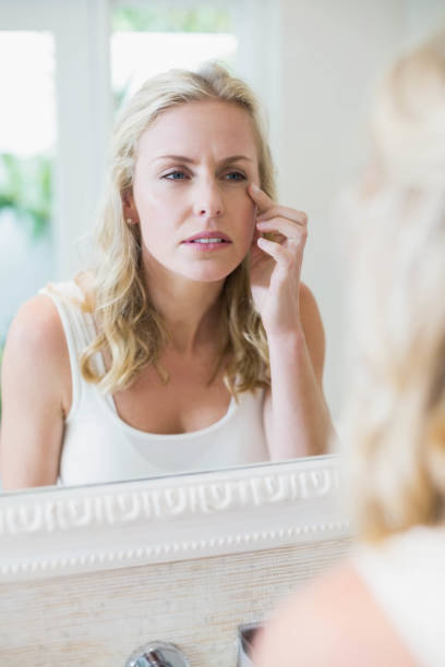 istock Beautiful woman looking at herself in the mirror 803254876