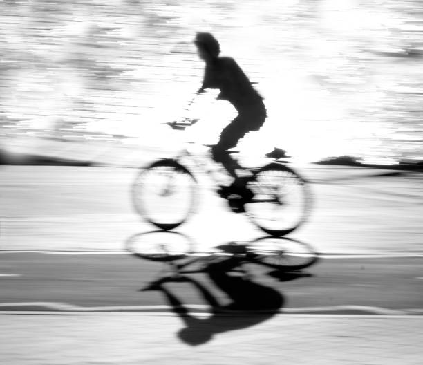 istock Defocused cyclist silhouette and shadow on a bike path 803265464
