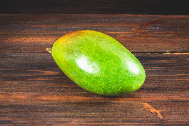 istock Tropical fruit mango on a wooden background, whole or sliced. 803266274