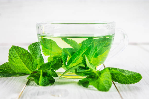 istock Mint tea in a cup on a white wooden table. 803267688