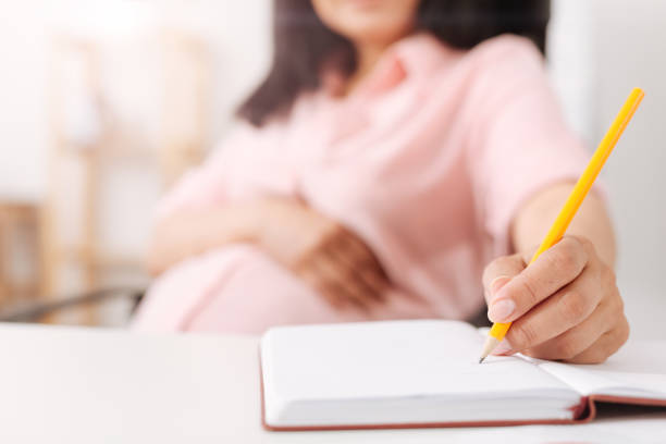 istock Close up of pregnant woman making notes 803271042