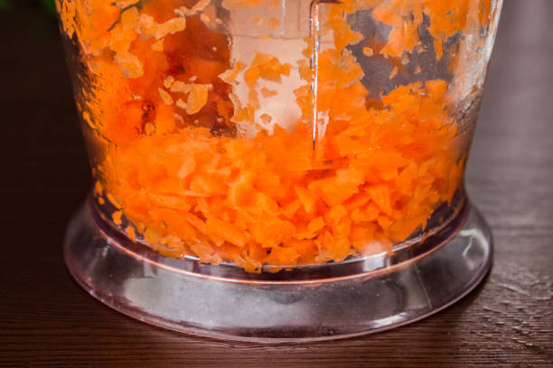 istock Carrots for borsch in an electric chopper. Soup cooking. 803279880