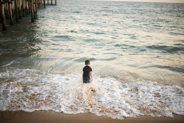 istock A child playing in the ocean waves. 803279924