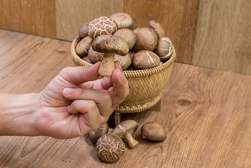 Fresh Shiitake mushroom In a bamboo basket on wooden table