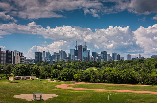 View of Toronto downtown architecture  and park in the foreground on the sunny day with dramatic sky.