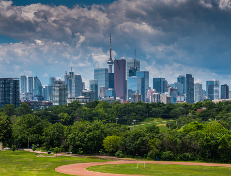 View of Toronto downtown architecture  and park in the foreground on the sunny day with dramatic sky.
