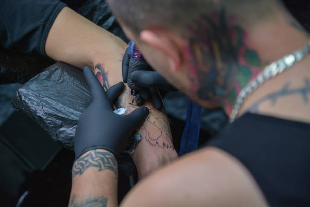 istock Tattoo Artist Working On a Arm Tattoo 803303868