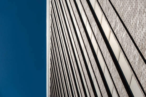 istock Red brick wall facade with long windows against blue sky 803304186
