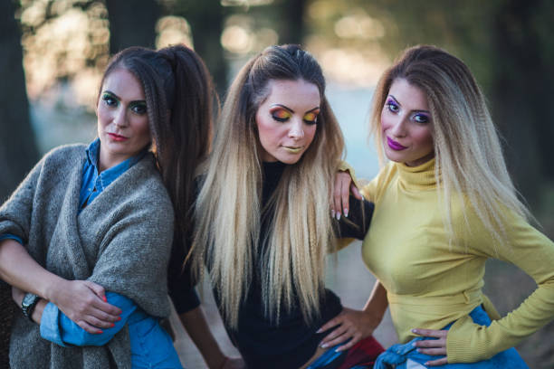 Generation relationship and outfit concept. Portrait adult daughter with mother. Two attractive elegant women wearing dresses, long curly hairs blonde mom and brown haired girl