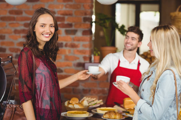 istock Smiling waiter serving a coffee to a customer 803319904