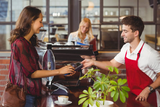 istock Smiling waiter handing a pin terminal 803322604