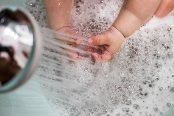 istock Baby hands playing with shower water 803325900