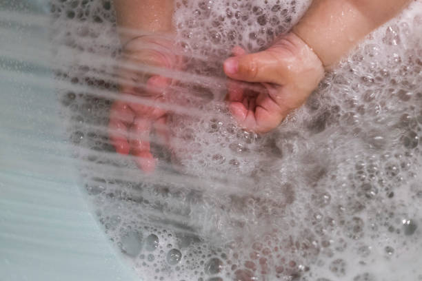 istock Baby hands playing with shower water 803325932