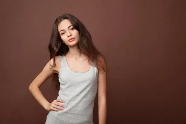 Photo of Beautiful girl in the studio on a brown background
