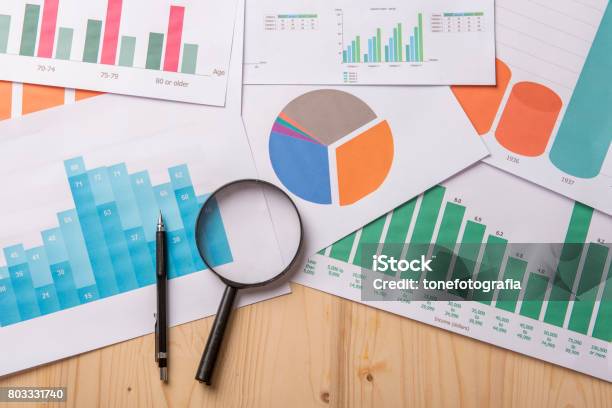 Lupe Und Dokumente Mit Analyticsdaten Liegen Auf Holztisch Stockfoto und mehr Bilder von Analysieren