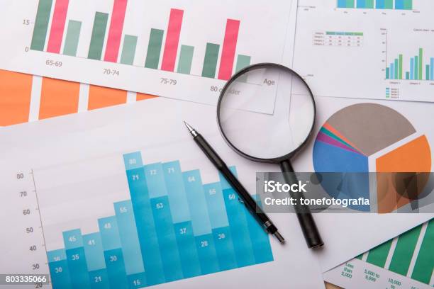 Lupe Und Dokumente Mit Analyticsdaten Liegen Auf Holztisch Stockfoto und mehr Bilder von Analysieren