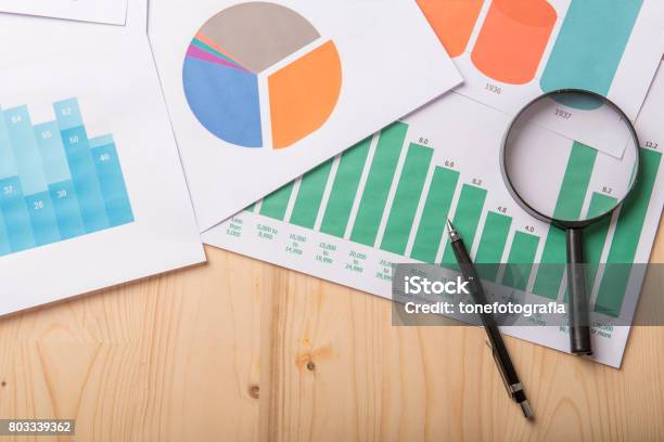 Lupe Und Dokumente Mit Analyticsdaten Liegen Auf Holztisch Stockfoto und mehr Bilder von Analysieren