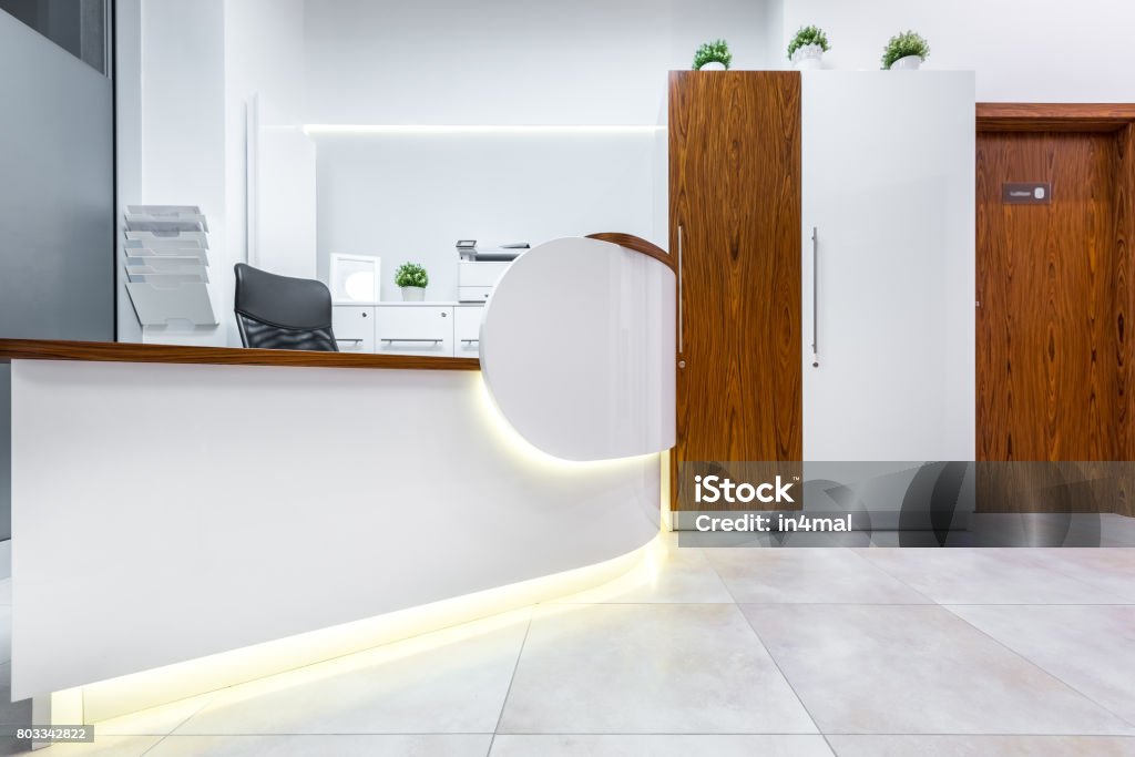 Interior with reception desk White interior with reception desk and wooden door Medical Clinic Stock Photo