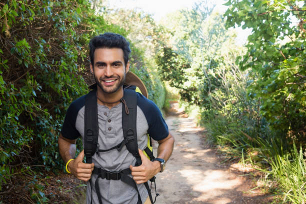 istock Portrait of smiling man with backpack walking in the forest 803352744