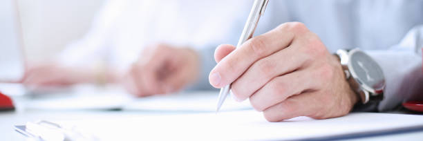 istock Businessman holding pen in hand 803358402