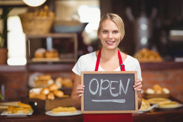 istock Pretty waitress with a chalkboard open sign 803370214