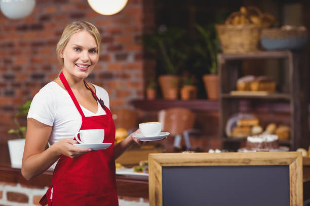 istock Pretty waitress holding two cups of coffees 803372354