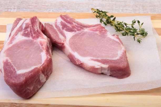 istock Raw pork chops, spices and rosemary on cutting board. Ready for cooking. 803394738