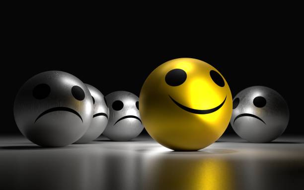 istock Yellow ball with happy face among so many silver sadness balls. 803405700