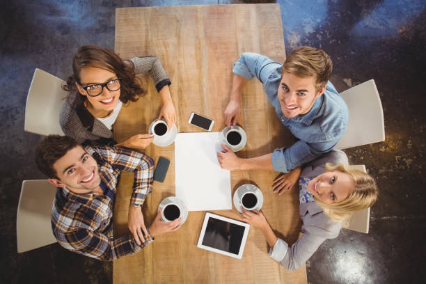 istock Smiling friends sitting and drinking coffee 803420514