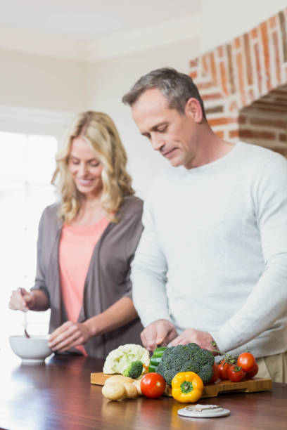 istock Cute couple slicing vegetables 803430012