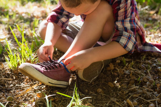 istock Boy tying shoelace in the forest 803433286