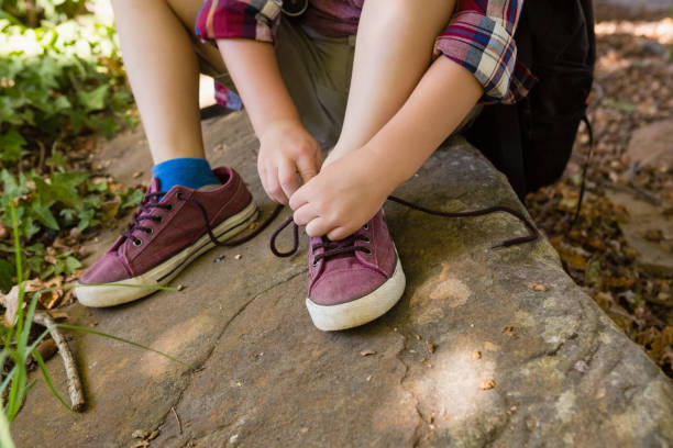 istock Boy tying shoelace in the forest 803434926